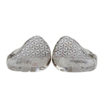 Two silver earbud casings with intricate patterns on a light gray background